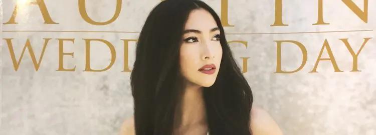 A woman with long black hair and a white top.