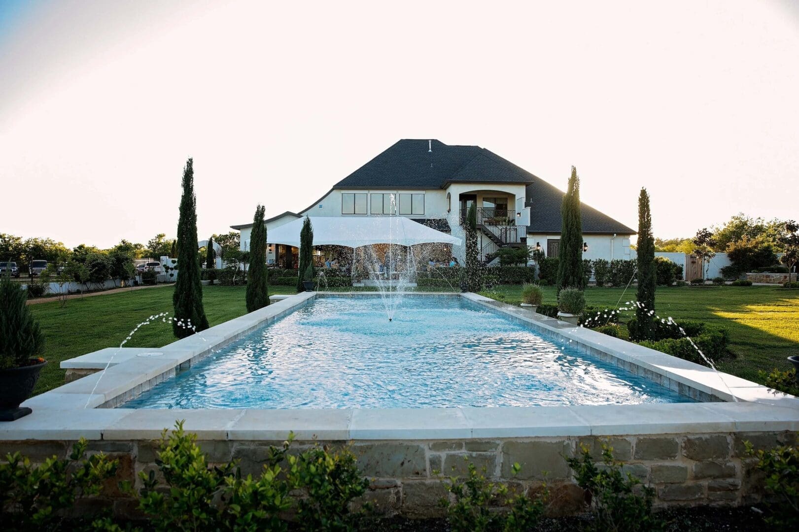 Here's an alt tag for the image: Pool and fountain at luxury home.