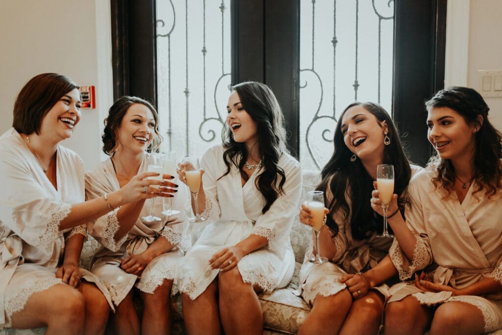 Bridesmaids toasting in robes.