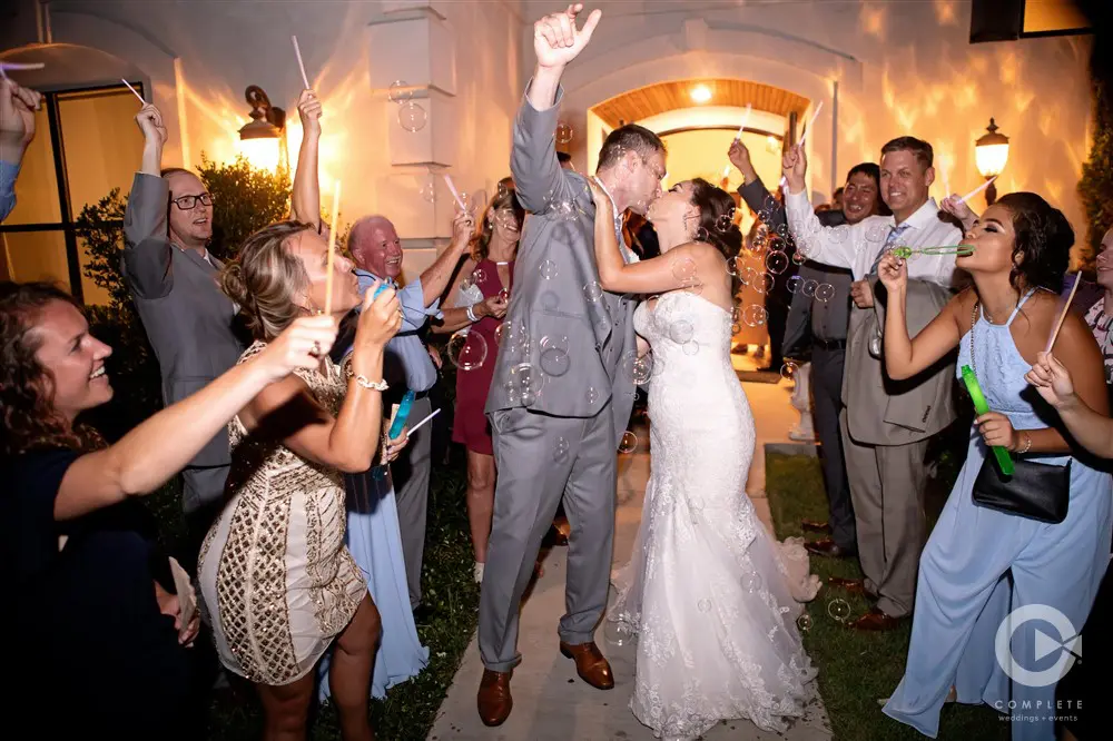 Bride and groom kissing, bubble send-off.